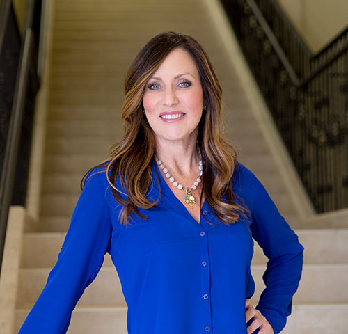 A woman standing on top of steps in front of stairs.